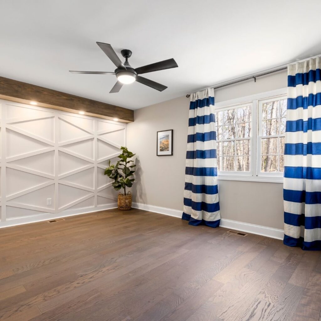black ceiling fan in a white room with striped blue and white curtains