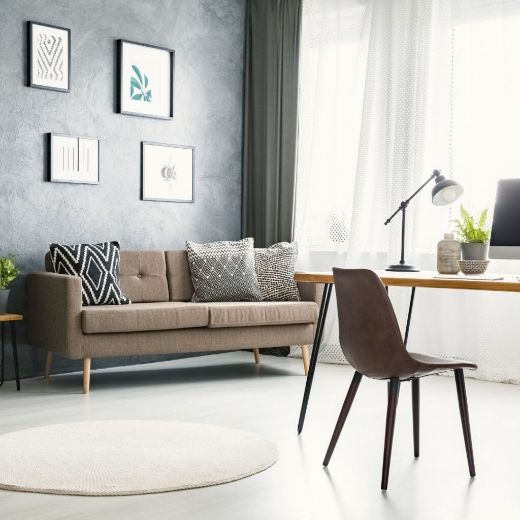 Home office with a desk and sofa and a table lamp