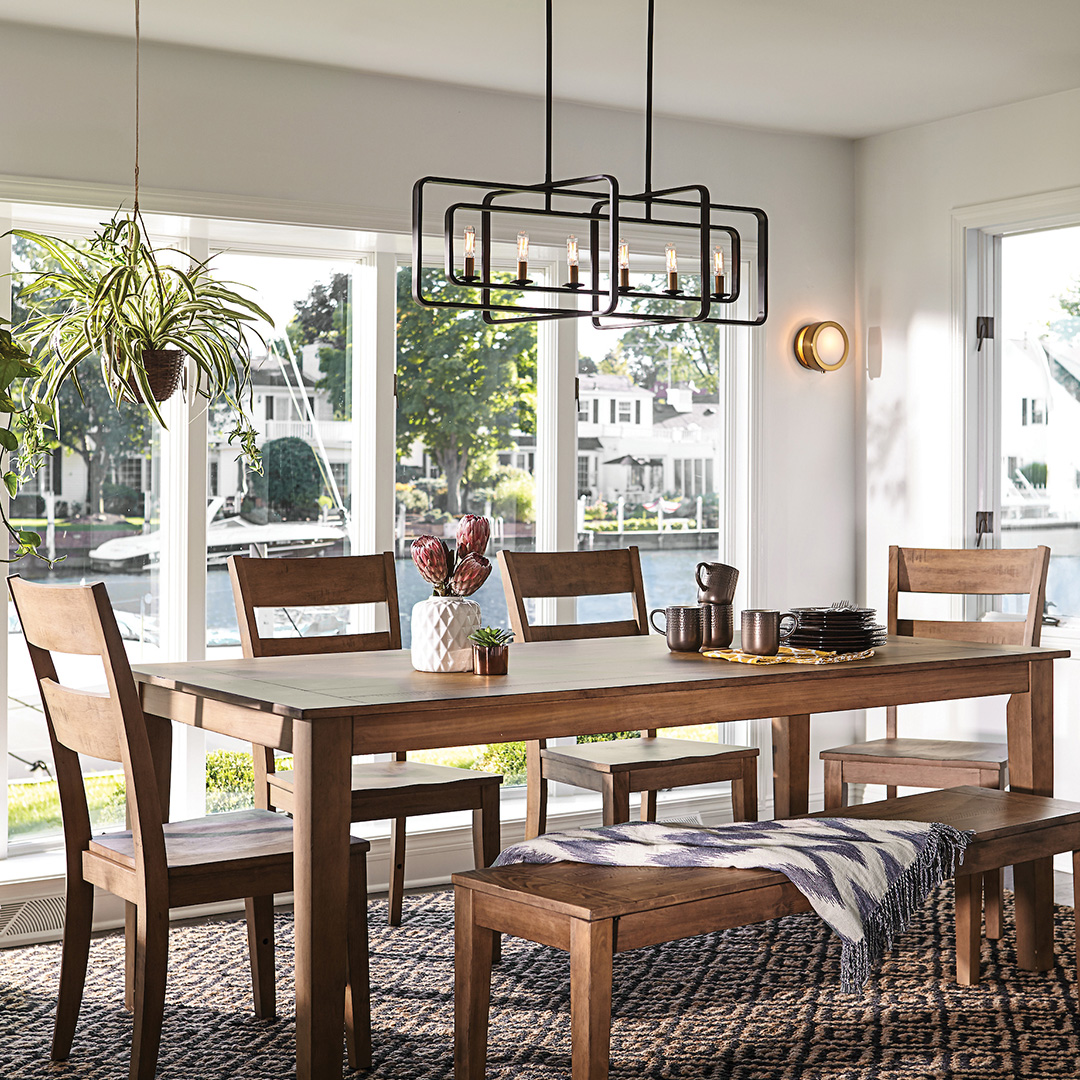 A black modern chandelier above a dining room table